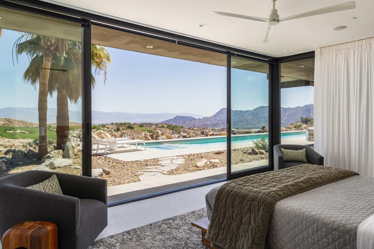 Bright, modern living room with a large sectional sofa and floor-to-ceiling windows